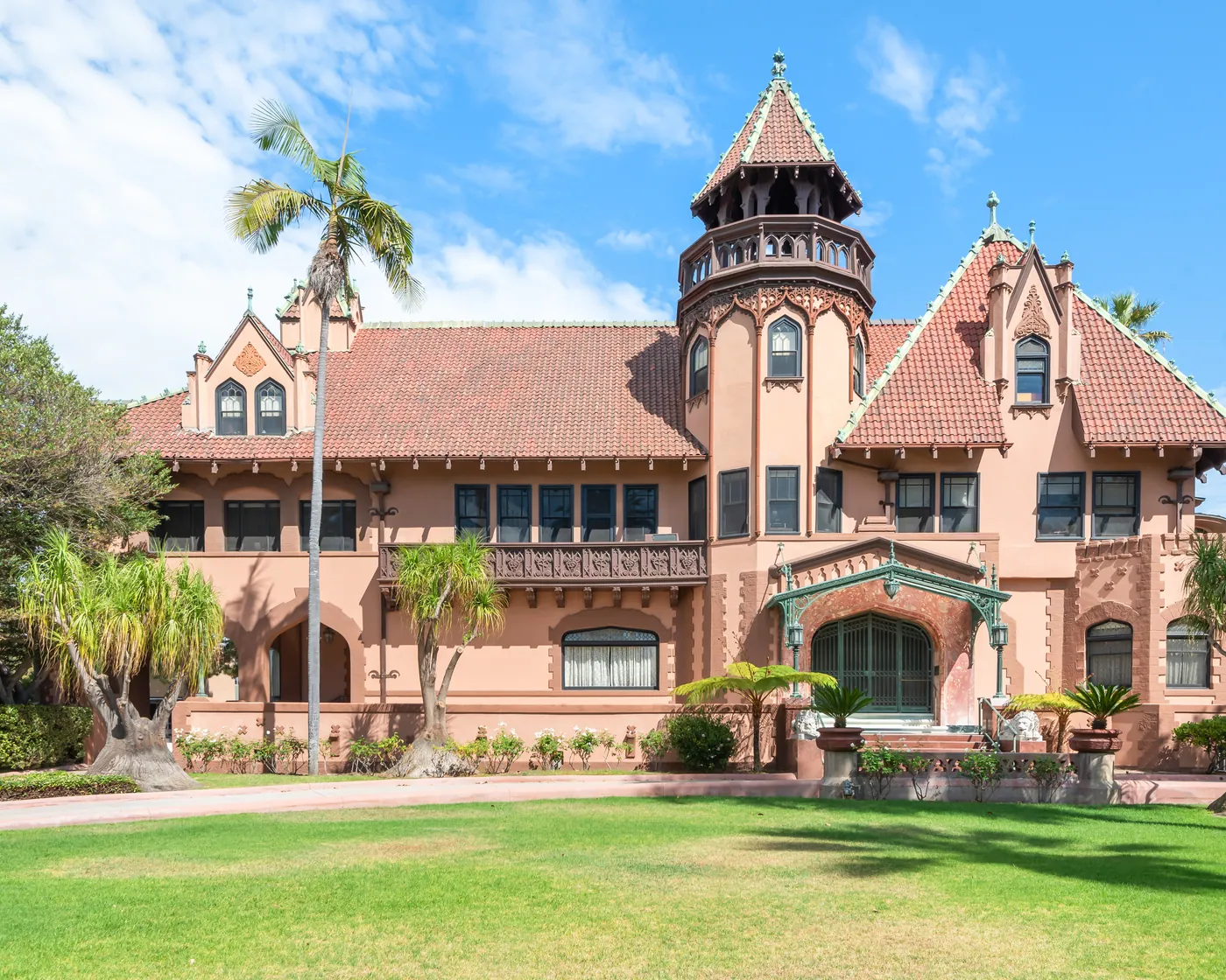 The turreted front facade of The Doheny Mansion above its lawn at Chester Place